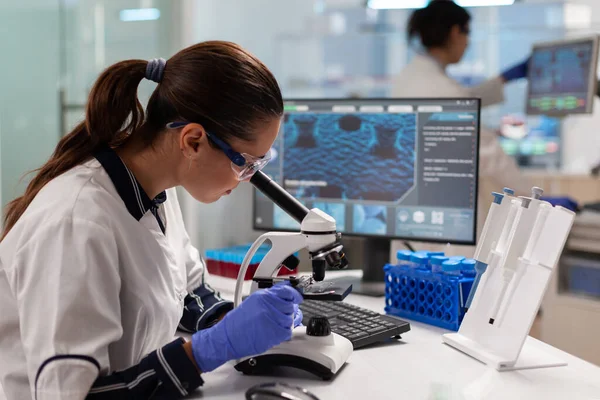 Healthcare scientist researcher vaccine looking at sample through microscope — Stock Photo, Image