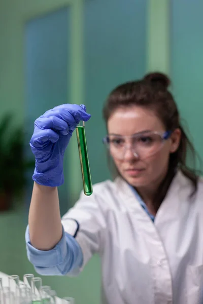 Primo piano della scienziata che guarda la provetta con il campione di DNA — Foto Stock