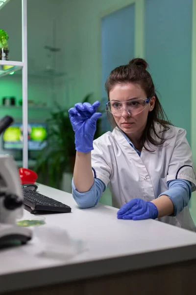 Biokemi forskare analysera grönt vätskeprov med hjälp av mikroskop — Stockfoto