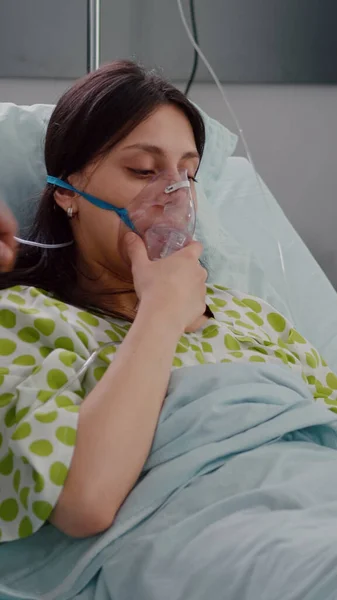 Paziente che riposa a letto affetto da malattia respiratoria mentre i medici monitorano il battito cardiaco — Foto Stock