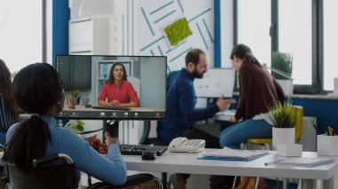 Yönetici hareketsiz bir şekilde tekerlekli sandalyede oturmuş, video görüşmesinde ortağıyla konuşuyor.