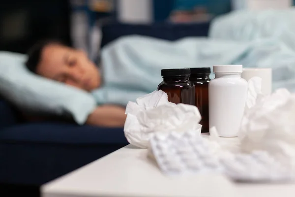 Primo piano dei farmaci per la donna malata che dorme sul divano — Foto Stock