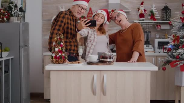 Rodzina robi selfie za pomocą smartfona korzystających ferie zimowe w kuchni urządzone xmas — Wideo stockowe