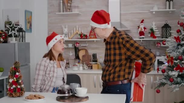 Enkelin mit Opa teilt Weihnachtsgeschenk mit Schleife — Stockvideo