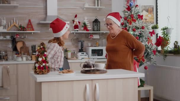 Abuela y nieta traer regalo de regalo de envoltura de Navidad con cinta en ella — Vídeos de Stock
