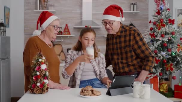 크리스마스 시즌을 즐기는 태블릿 컴퓨터로 온라인 xmas 영화를 보는 행복 한 가족 — 비디오