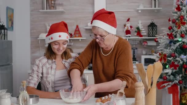 Gradma with granddaughter mixing ingredients egg with flour preparing homemade traditional dough — Stock Video