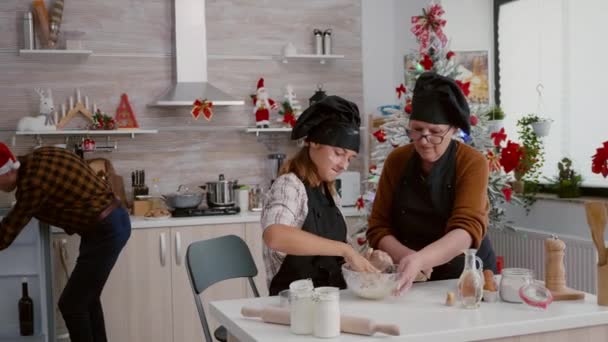 Grandma with granddaughter preparing homemade cookies dough in kitchen bowl — Stock Video