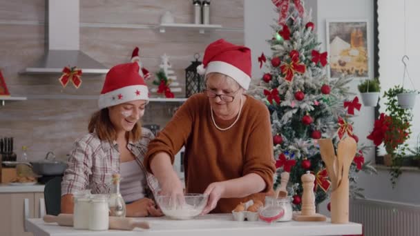 Бабуся і дідусь допомагають онуці готувати домашнє традиційне тісто для печива на кулінарній кухні — стокове відео