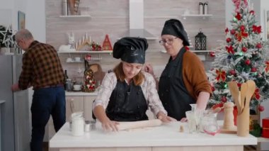 Büyükannem ve büyükbabam, torunuma geleneksel ev yapımı hamuru hazırlamada yardım ediyor.