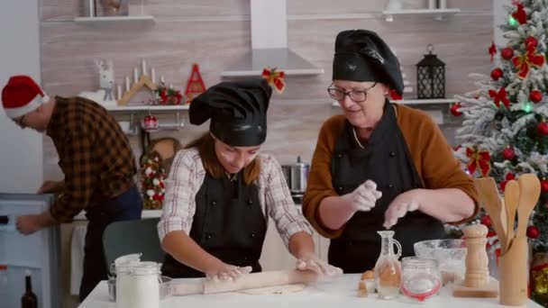 Granddaughter making homemade gingerbread dough using kitchen rolling pin — Stock Video