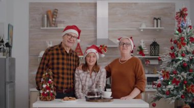 Çevrimiçi video görüşmesi sırasında Noel Baba şapkası takan bir aile toplantısı.
