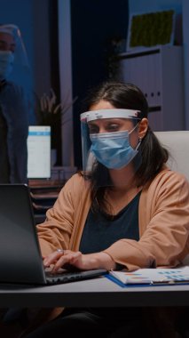 Kovid19 'a karşı maske ve güneşlik takan işkolik bir iş kadını.