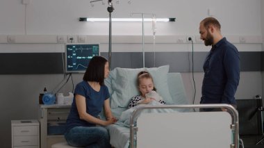 Endişeli aile, hasta kızı uyurken izleme uzmanlığını tartışıyor.