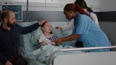 Hasta hasta yatakta dinleniyor. Oksijen tüpü takıyor. Pediyatrist doktorla konuşuyor.