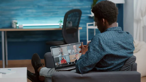 Africano americano homem unsing laptop para bate-papo conferência on-line internet com seus colegas de trabalho — Fotografia de Stock