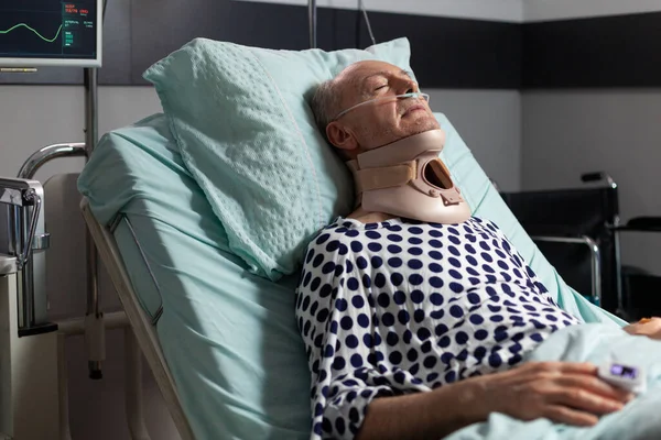 Idős férfi feküdt a kórházi szobában ágy visel cerival gallér — Stock Fotó