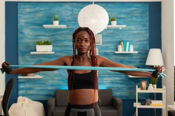 Donna nera che esercita la forza muscolare con elastico — Foto Stock