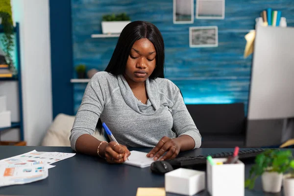 Afrikaans-Amerikaanse student schrijven middelbare school huiswerk op notebook — Stockfoto