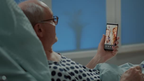 Patient âgé malade parlant sur vidéocall avec sa famille à l'hôpital — Video