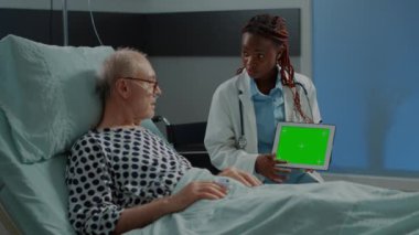 Afro-Amerikalı doktor tablette yeşil ekran gösteriyor