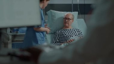 Hastane koğuşundaki hasta hasta sayacını kontrol eden hemşire.