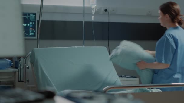 Ιατρική νοσοκόμα προετοιμασία νοσοκομειακή πτέρυγα κρεβάτι με μαξιλάρι και κουβέρτα — Αρχείο Βίντεο