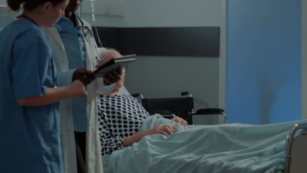 Többnemzetiségű egészségügyi személyzet és beteg a kórházi osztályon — Stock videók