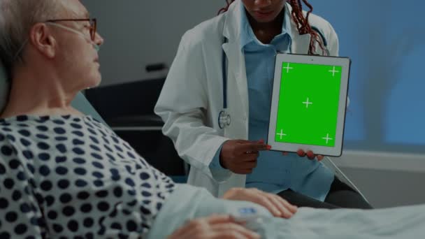 Жінка-хірург тримає зелений планшет у лікарняному палаті — стокове відео