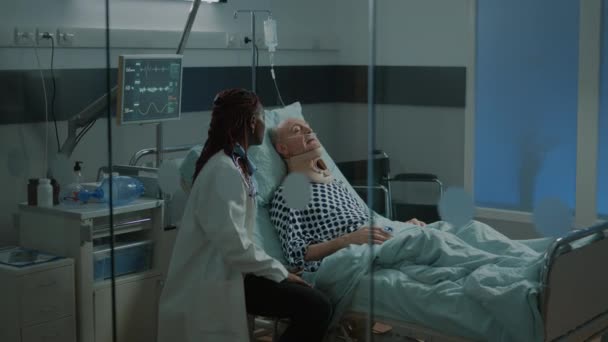 Afrykański lekarz rozmawiający z chorym pacjentem w szpitalu — Wideo stockowe