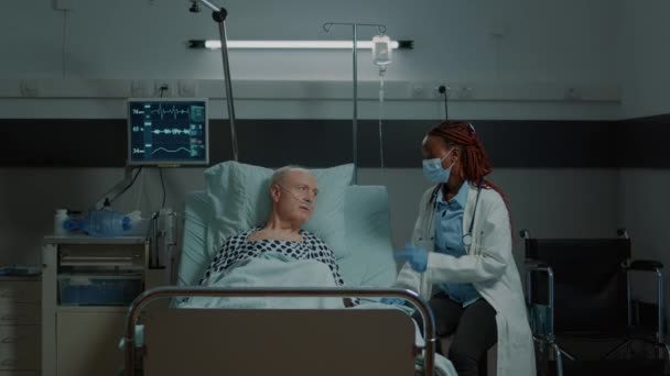 Médico afroamericano hablando con paciente enfermo en sala de hospital — Vídeo de stock