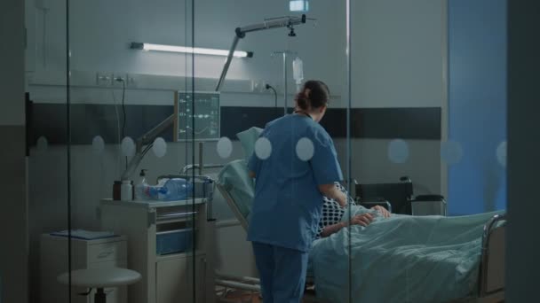 Pacjent chory na oddziale szpitalnym otrzymuje pomoc od zespołu medycznego — Wideo stockowe