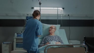 Hasta yaşlı adam hastane koğuşunda röntgen sonuçları alıyor.