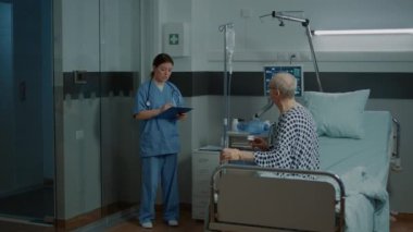 Hemşire ve Afrikalı Amerikalı doktor hastalarını gezdiriyorlar.