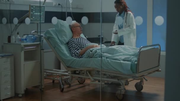 Patient malade couché dans un lit d'hôpital à l'établissement — Video