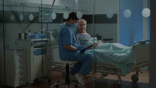 Nurse and african american medic checking on patient — Stock Video