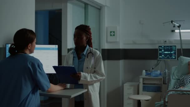 Médico afroamericano revisando pruebas para pacientes enfermos — Vídeo de stock