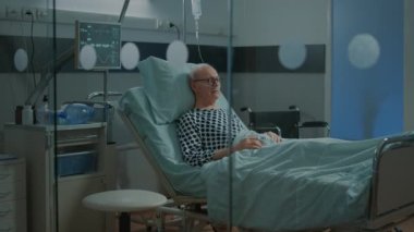 Burun oksijen tüpü ve serum takılı hasta.