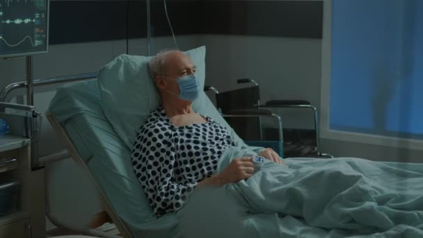 Paziente malato seduto in ospedale letto reparto con maschera viso — Video Stock