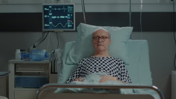Paciente mayor acostado en cama de hospital en la unidad de salud — Vídeos de Stock