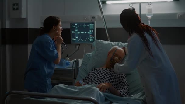 African american doctor placing oxygen tube on patient — Stock Video