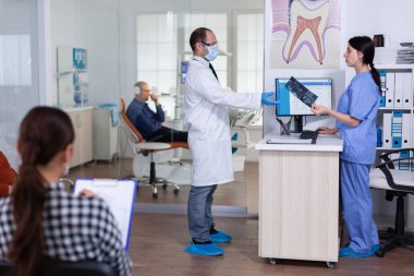 Profesyonel doktor hastayı muayene etmeden önce diş röntgeni istiyor.