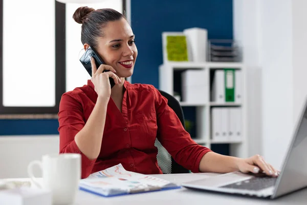 Occupata donna d'affari che risponde al telefono seduta alla scrivania sul posto di lavoro aziendale — Foto Stock