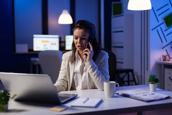 Femme d'affaires ayant un appel téléphonique dans le bureau de démarrage tard dans la nuit travaillant au projet de marketing — Photo