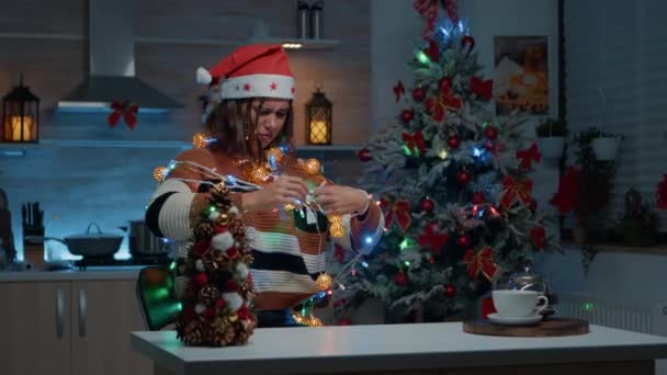 Ung vuxen försöker dekorera hemmet i julstämning — Stockvideo