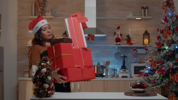 Mujer festiva poniendo regalos en el mostrador de la cocina — Vídeos de Stock