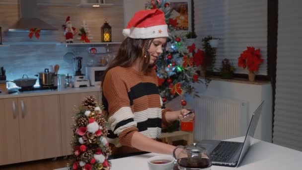 Jonge vrouw met santa hoed doen online winkelen — Stockvideo