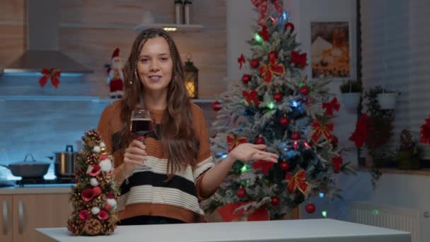 Młoda kobieta rozmawia przez wideo połączenie trzymając kieliszek wina — Wideo stockowe