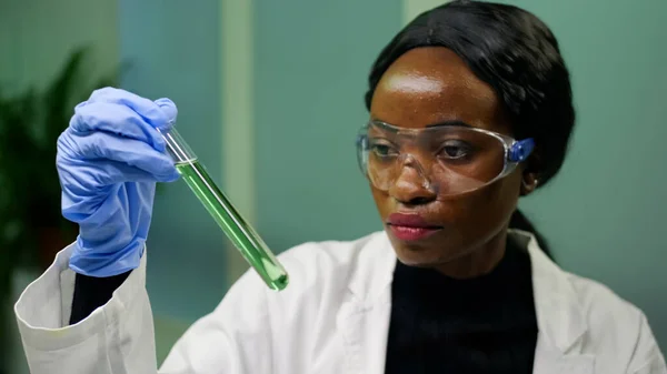 Bioloog vrouw houdt reageerbuis met genetische vloeistof onderzoeken groene DNA monster — Stockfoto