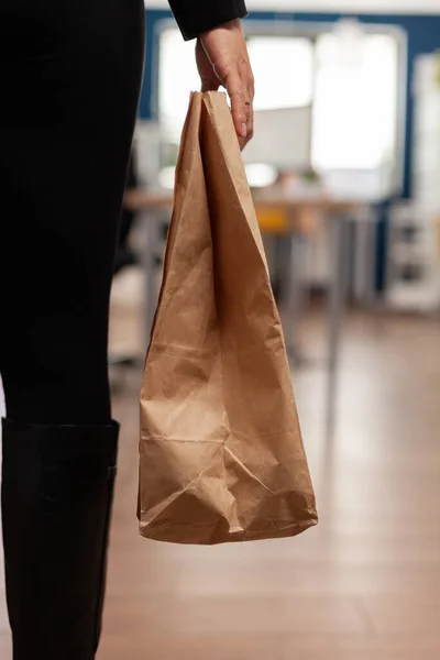 Businesswoman holding delivery takeaway food meal order paper bag during takeout lunchtime — Stock Photo, Image